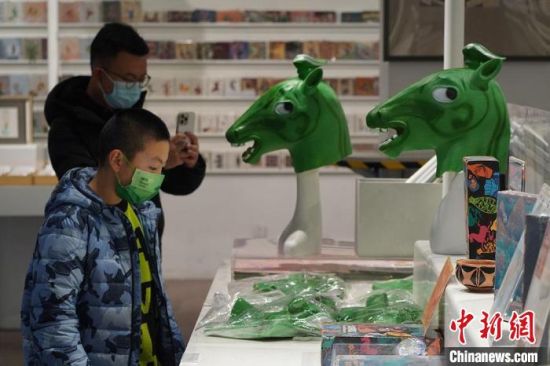 圖為“神馬來了”銅奔馬頭套吸引參觀者駐足?！【琶赖┰?攝