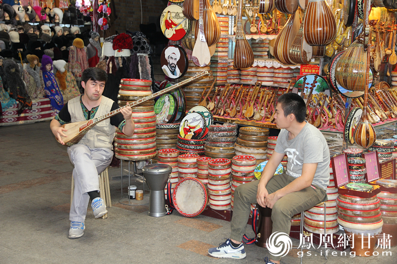 烏魯木齊二道橋巴扎內，店主正在向客人展示樂器。楊文遠 攝