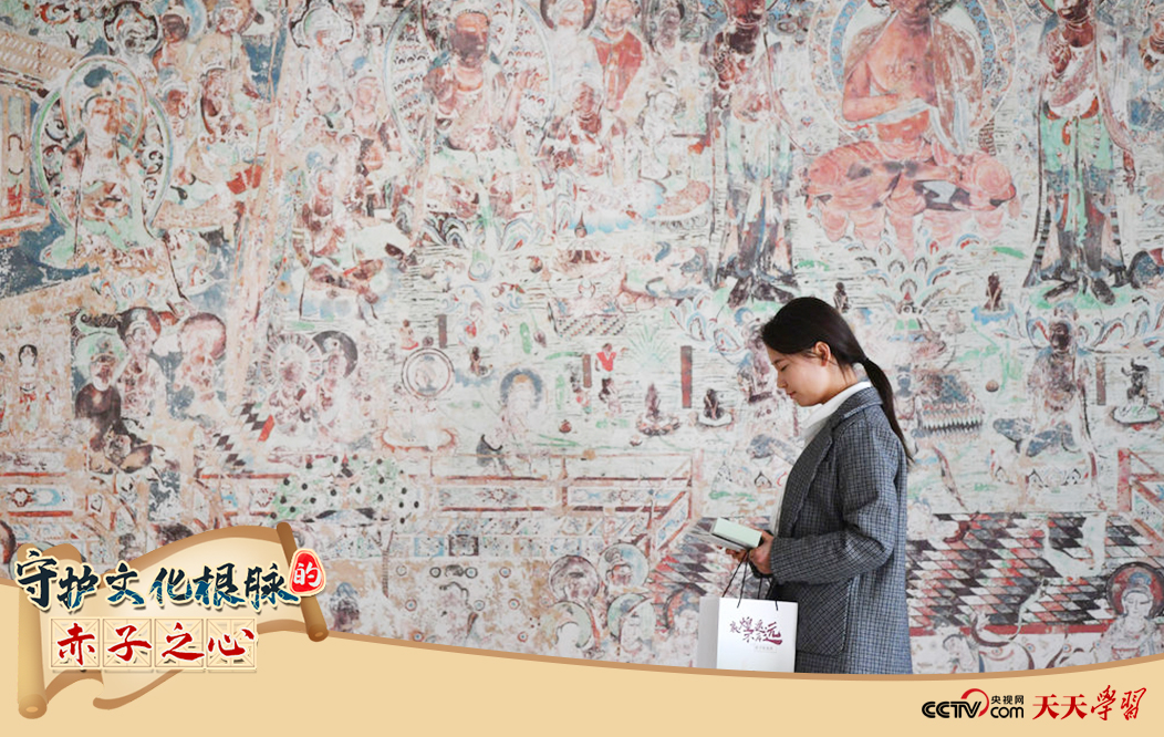 2023年4月25日,敦煌研究院文物數(shù)字化保護團隊創(chuàng)意營銷人員廖雪婷從一幅高保真復制壁畫前走過。